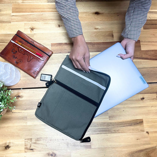 Slim olive green canvas laptop pouch with a minimalist design and secure tablet sleeve for travel.
