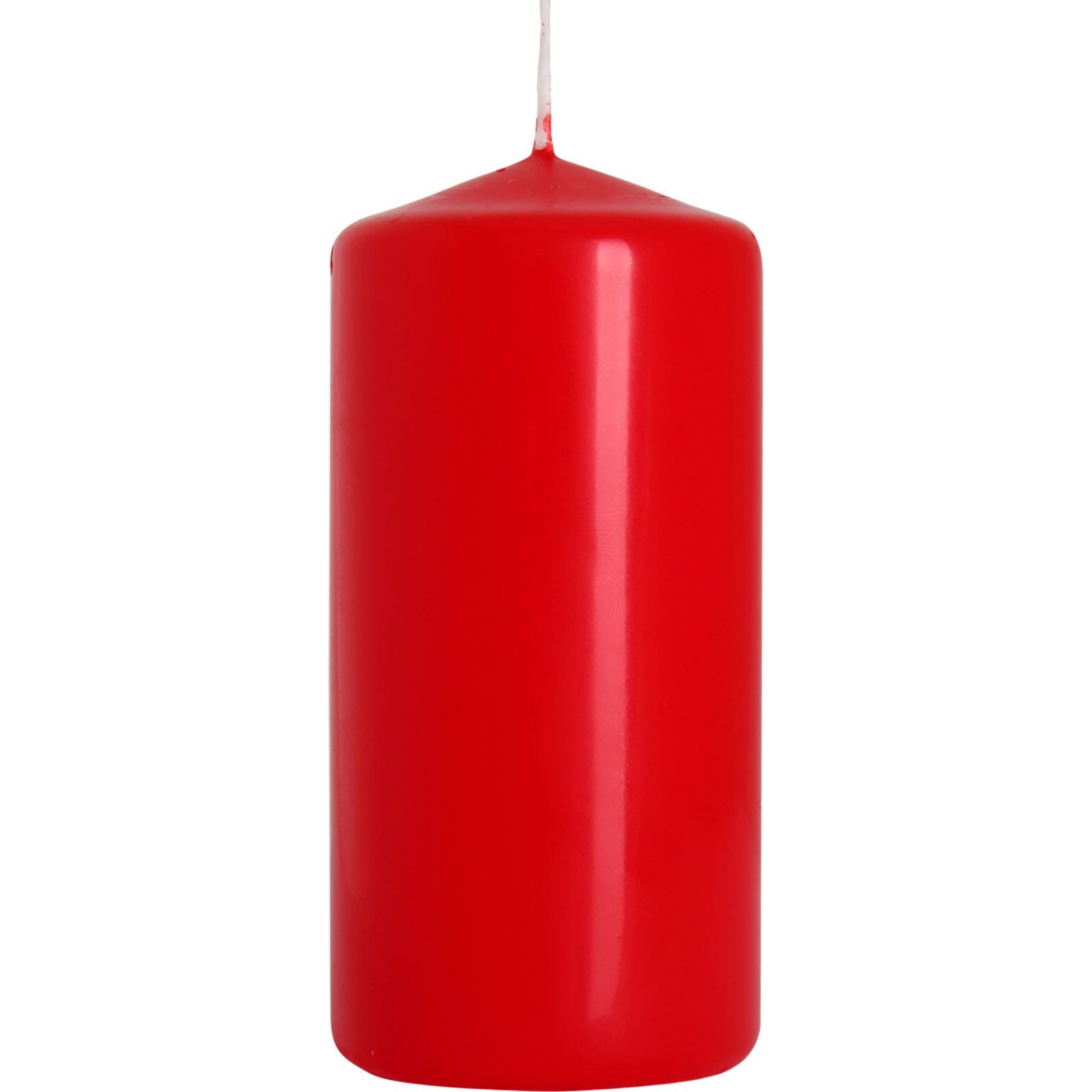 Solid red cylindrical pillar candle standing on a neutral surface with a clean background.
