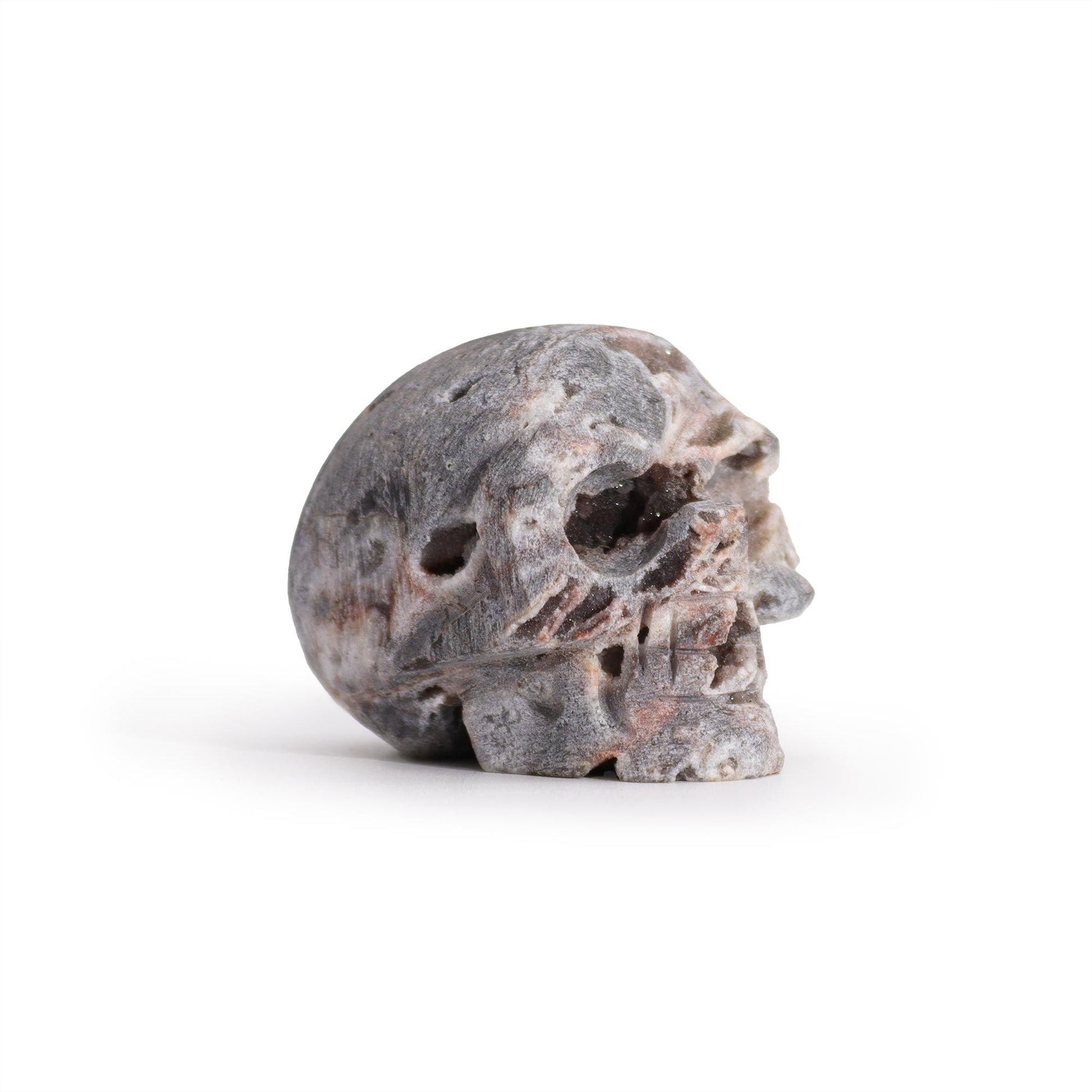 Intricately carved crystal skull made from a natural calcite geode showing internal crystalline structures.