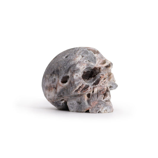 Intricately carved crystal skull made from a natural calcite geode showing internal crystalline structures.