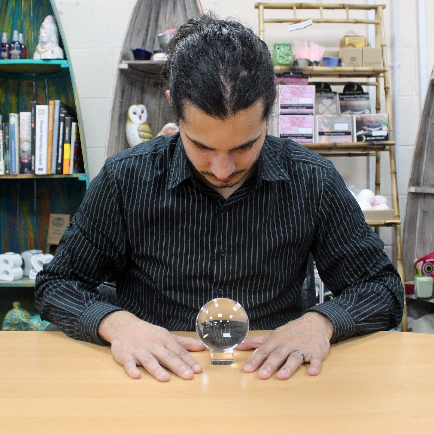 Clear 80mm optical glass crystal ball resting on a simple dark wooden stand against a neutral background.