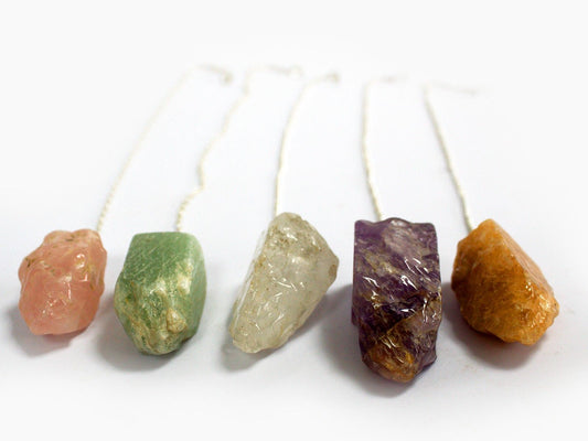 Assorted natural gemstone pendulums in various colours with silver-tone chains and matching bead ends.