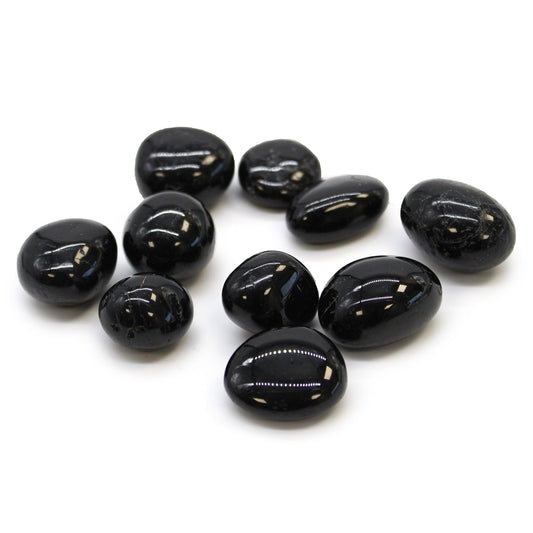 Large, highly polished black tourmaline tumbled stone with a smooth, glossy surface and natural organic shape.