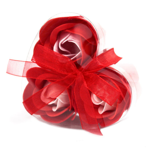Three delicate red soap roses arranged beautifully inside a heart-shaped gift box for a romantic bath experience.