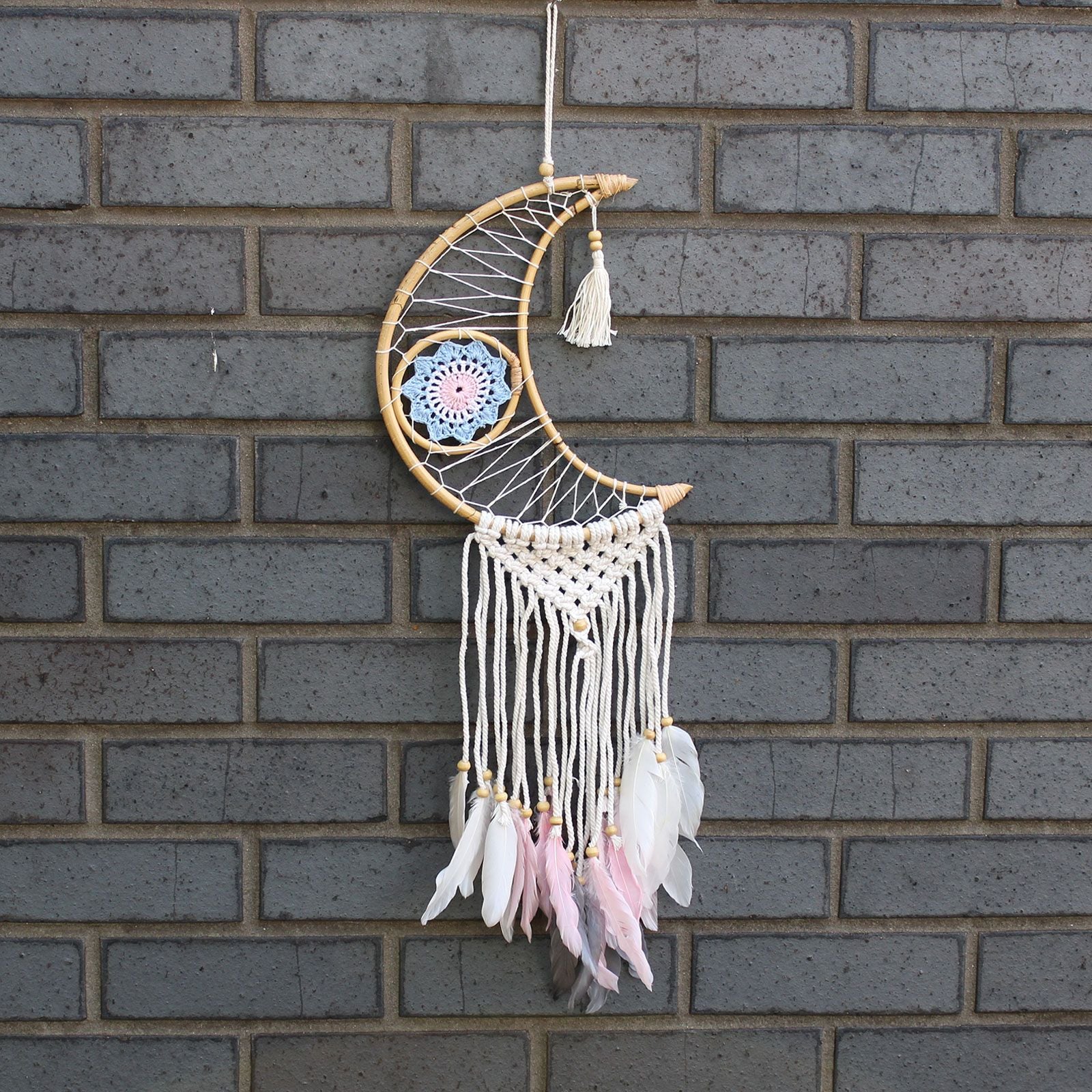 Handcrafted macrame crescent moon dream catcher featuring a blue evil eye symbol and delicate woven textures.
