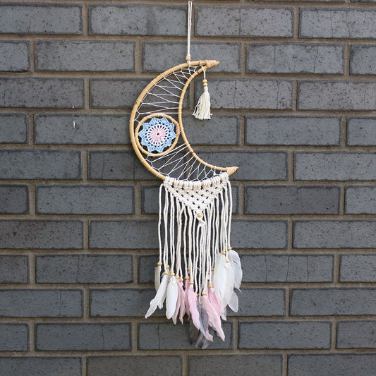 Handcrafted macrame crescent moon dream catcher featuring a blue evil eye symbol and delicate woven textures.