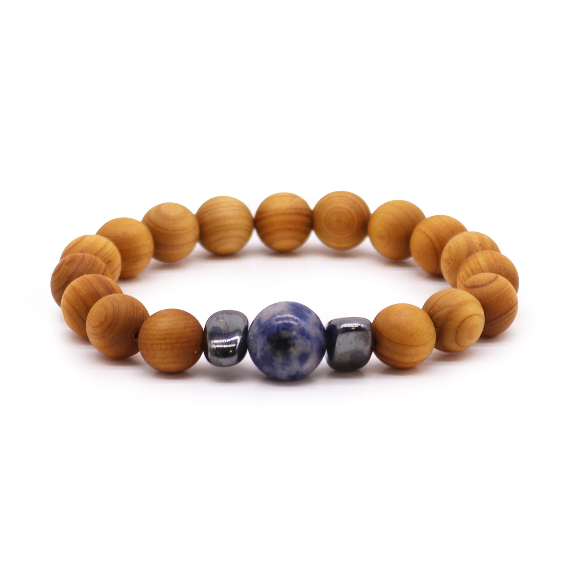 Handcrafted cedarwood bangle with a blue sodalite gemstone accent for throat chakra balance.