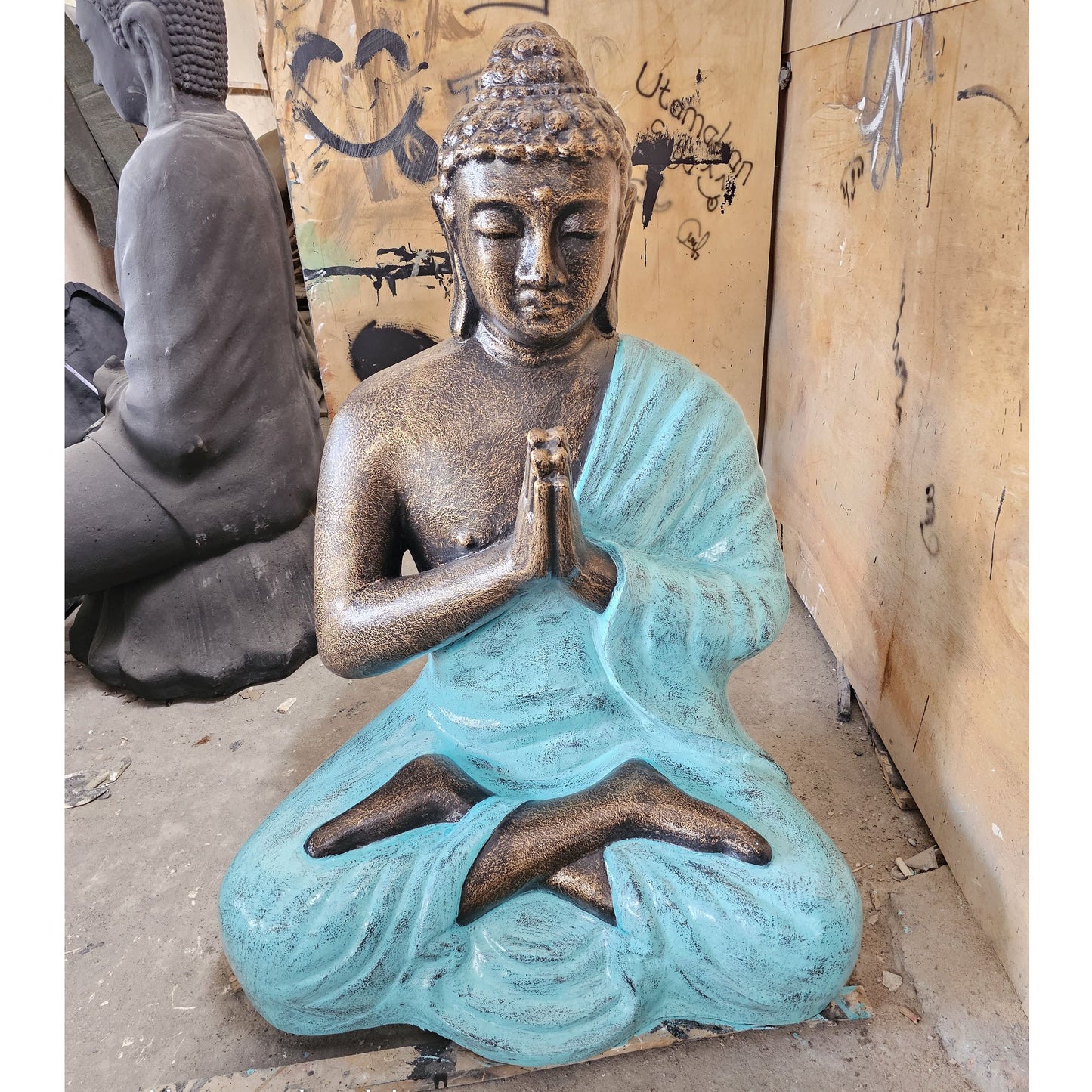 Large turquoise and gold praying Buddha statue standing 1.2 metres tall in a serene meditative pose.