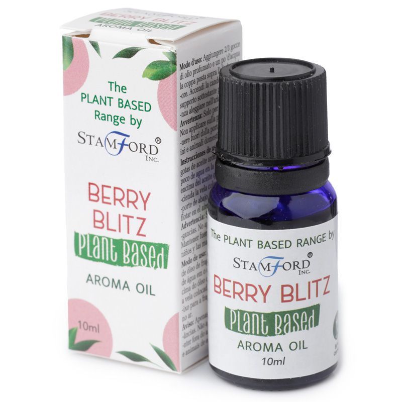 A bottle of plant-based aroma oil labelled Berry Blitz, placed next to a bowl of fresh mixed berries.