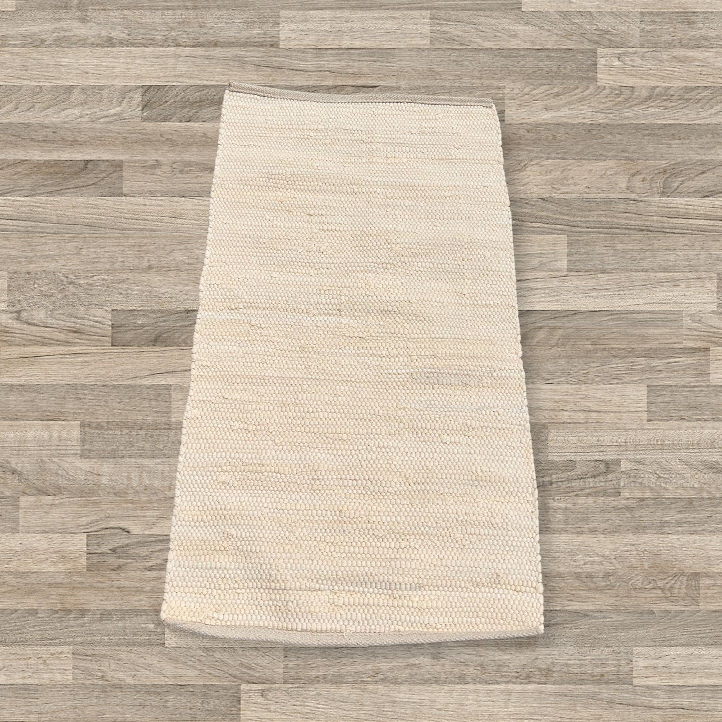 Small cream-coloured handloom cotton rug with a textured weave on a neutral background.