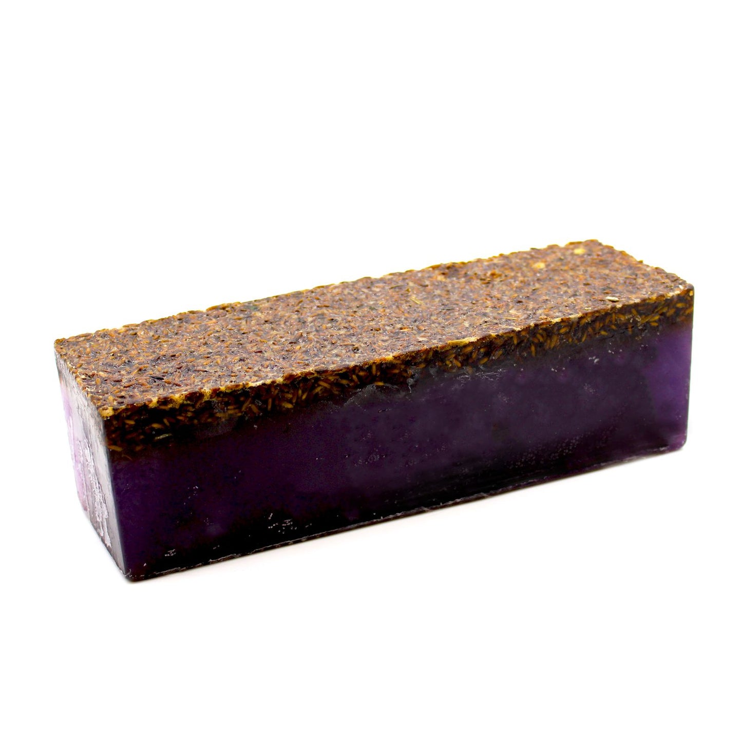 Hand-crafted lavender soap loaf topped with dried purple lavender flowers and showing layered textures.
