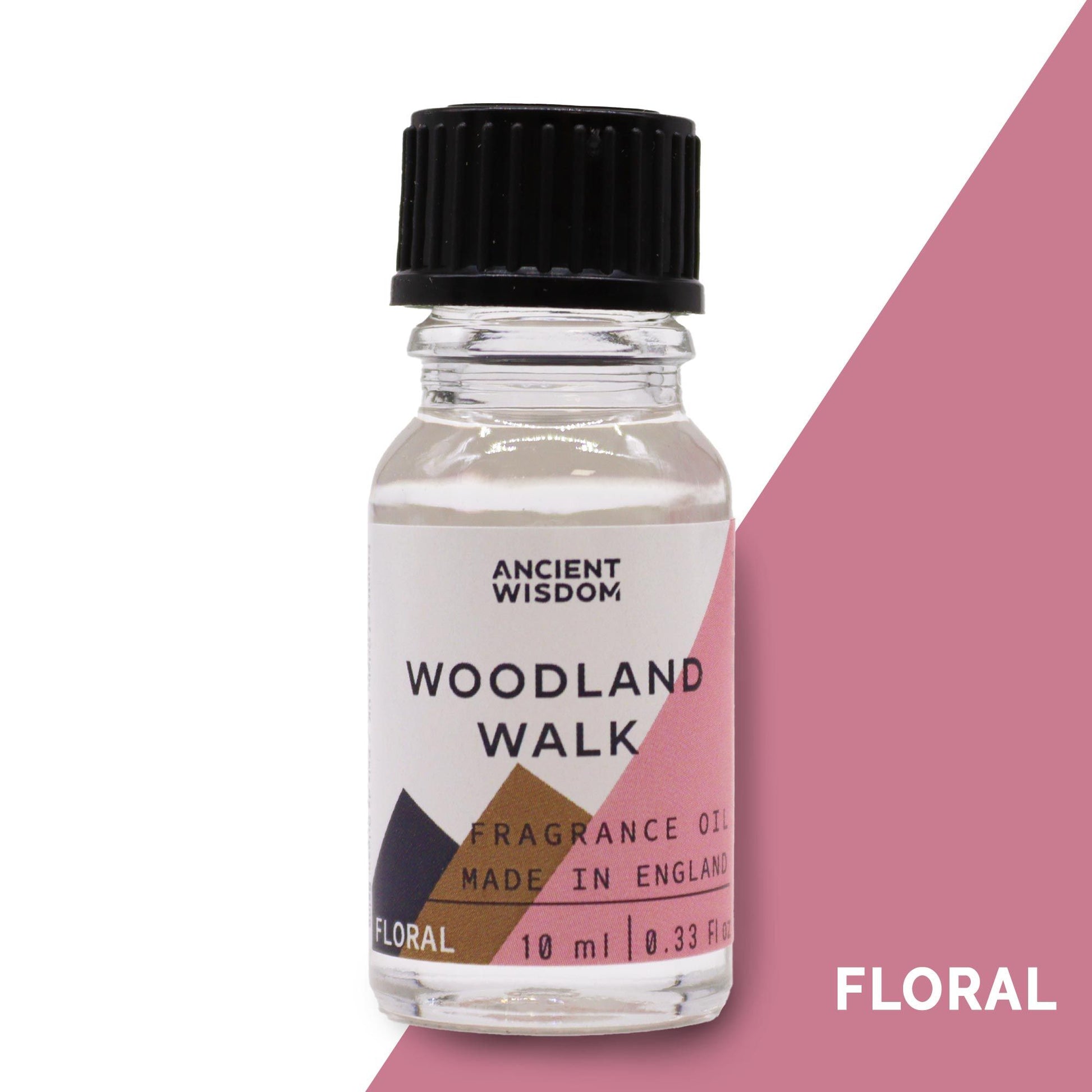 A small 10ml amber glass bottle of fragrance oil with a forest-themed label on a neutral background.