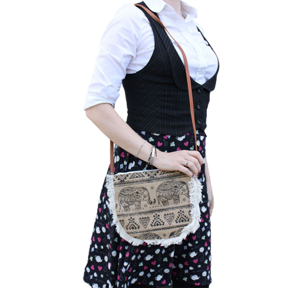 Soft washed jute bag featuring a screen-printed elephant design, cotton fringe trim, and a brown leather-effect strap.