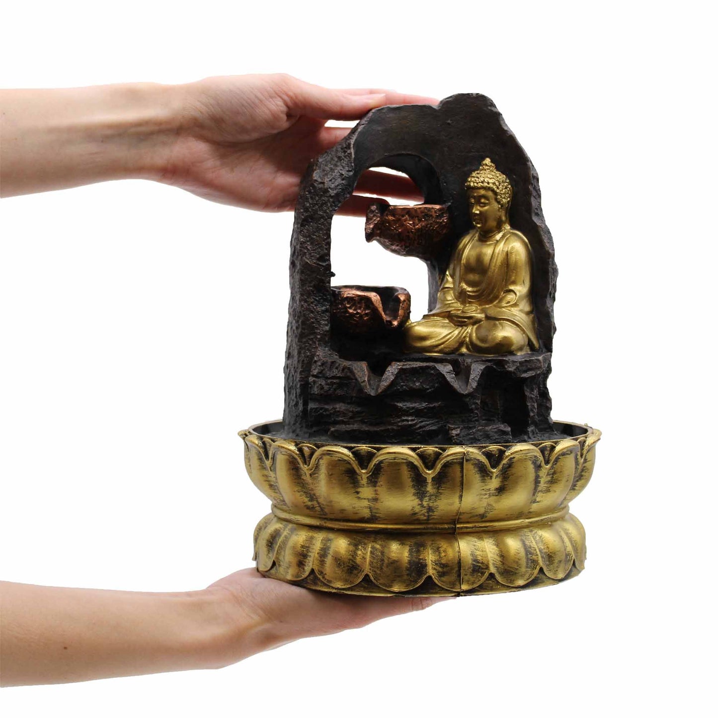 Serene golden meditating Buddha statue seated on a circular base with flowing water and polished river stones.