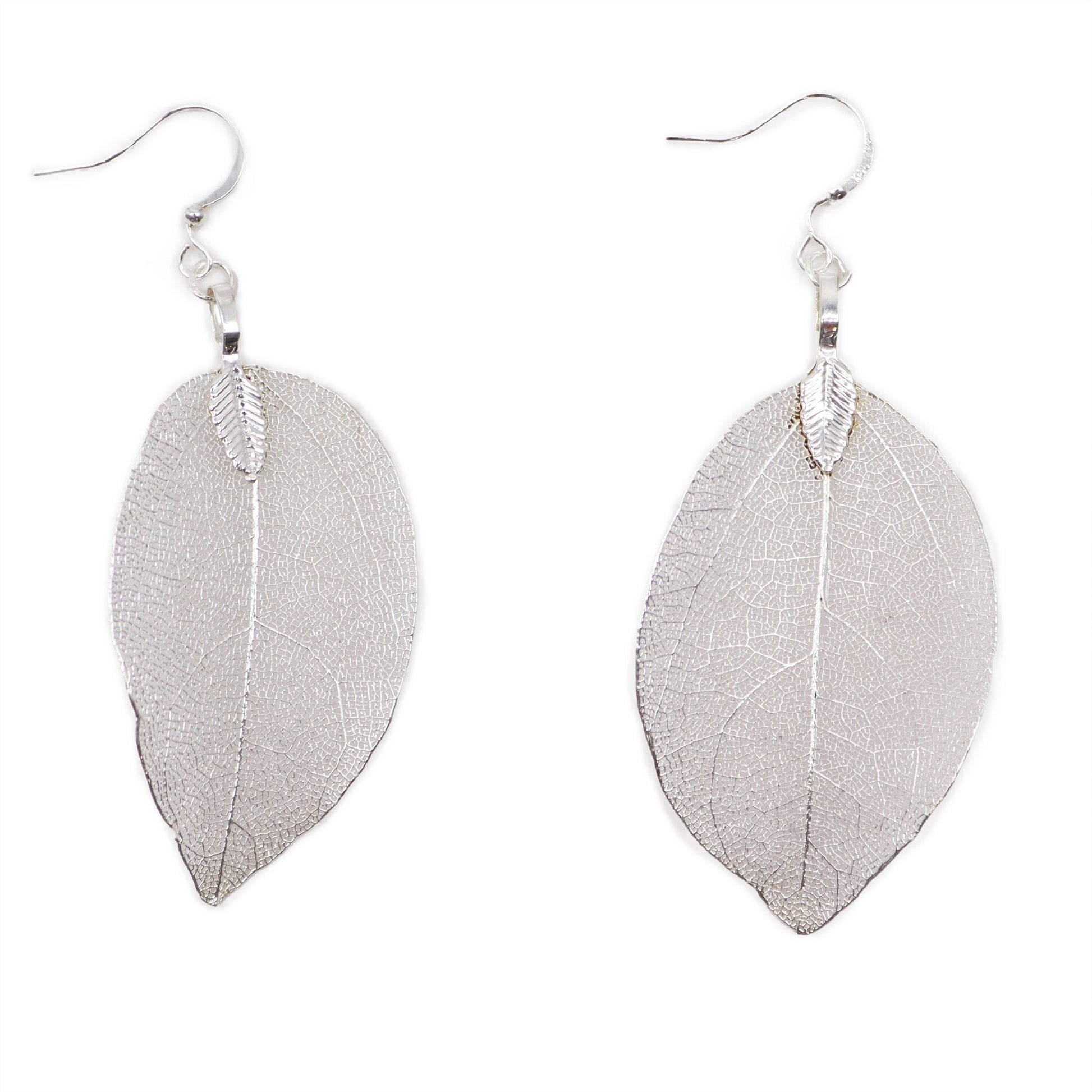 Detailed silver earrings crafted from real leaves, showing natural intricate skeletal leaf patterns.