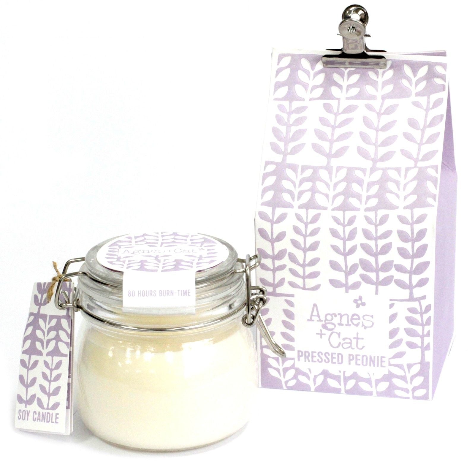 Large glass jar candle with white wax and a floral label, featuring a metal wire-lock lid on a neutral background.