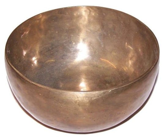 Large hand-hammered metal Tibetan singing bowl with a traditional matte finish and a wooden striker.