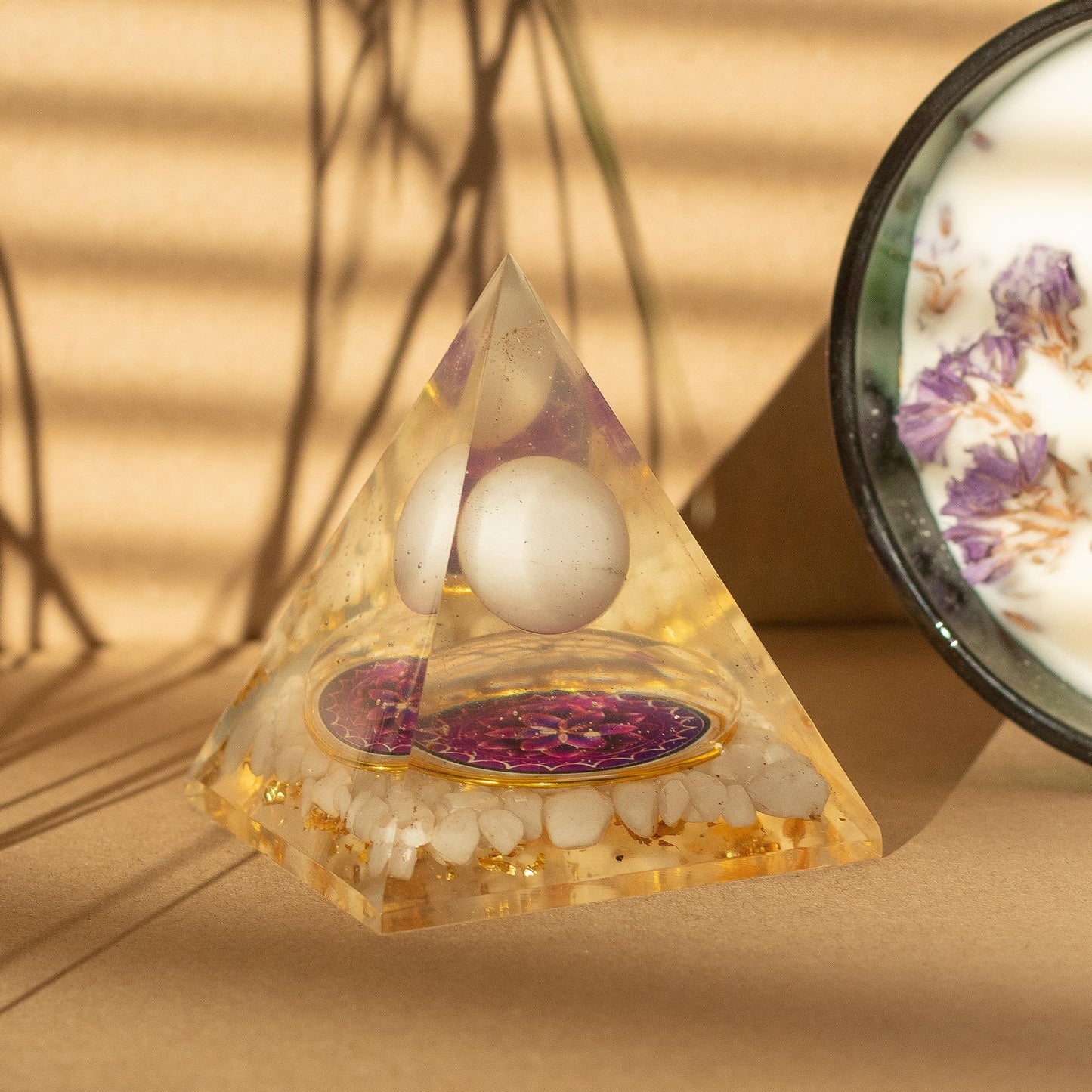 Orgonite pyramid featuring a white quartz sphere floating over a mandala with quartz chunks and gold flakes at the base.