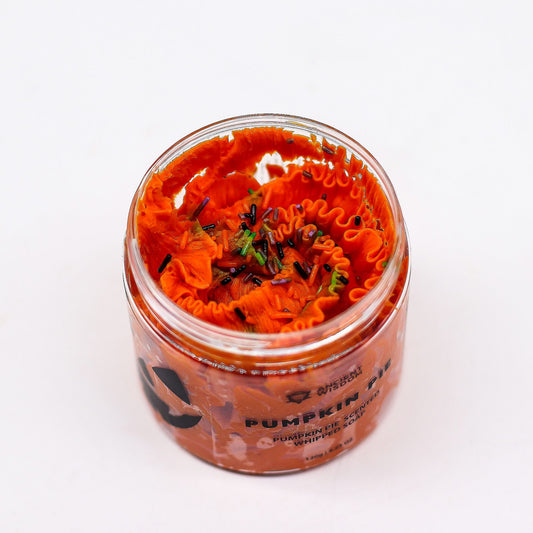 Creamy orange whipped soap in a clear jar, featuring a rich texture reminiscent of pumpkin pie filling.