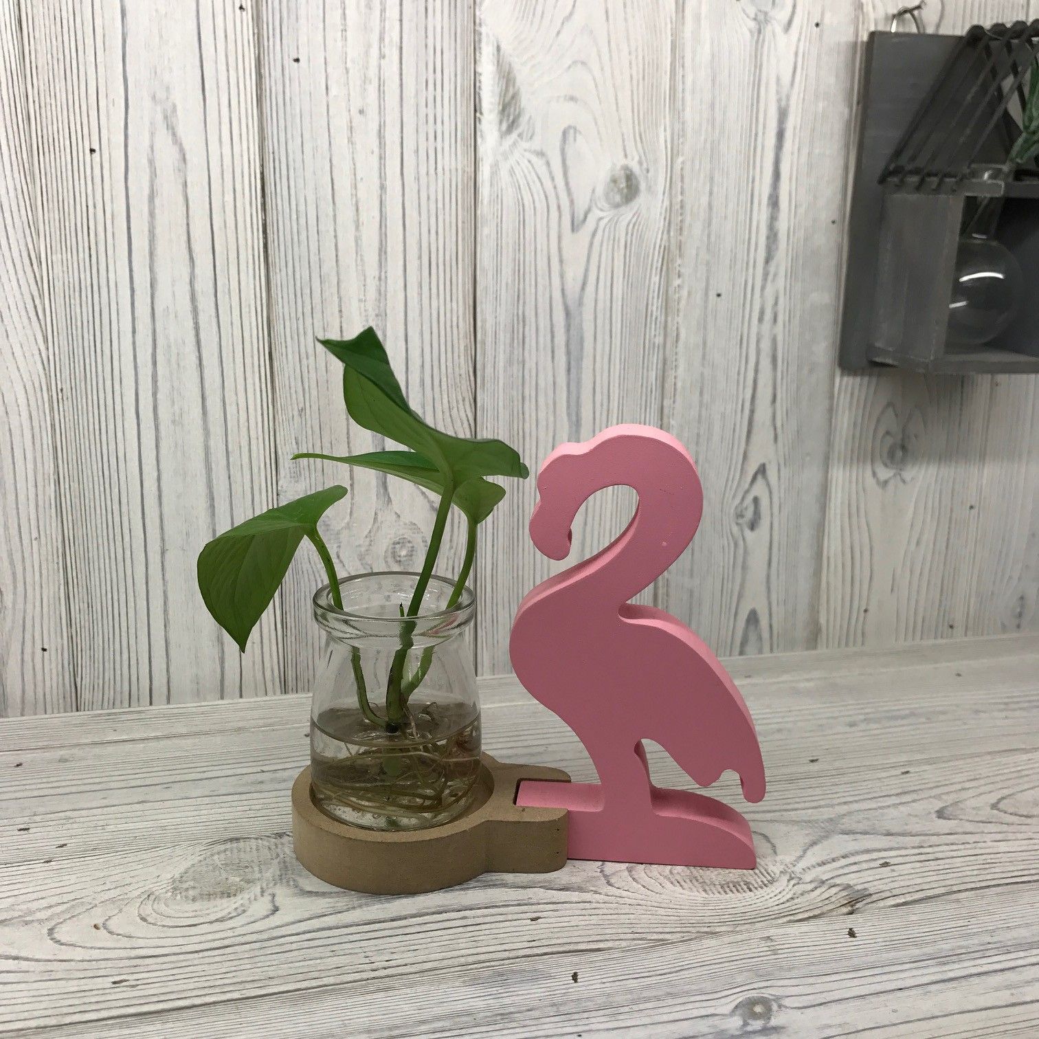 Stylish pink flamingo indoor planter with a glass propagation tube for hydroponic plants and flowers.