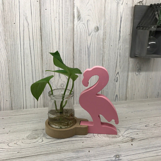 Stylish pink flamingo indoor planter with a glass propagation tube for hydroponic plants and flowers.