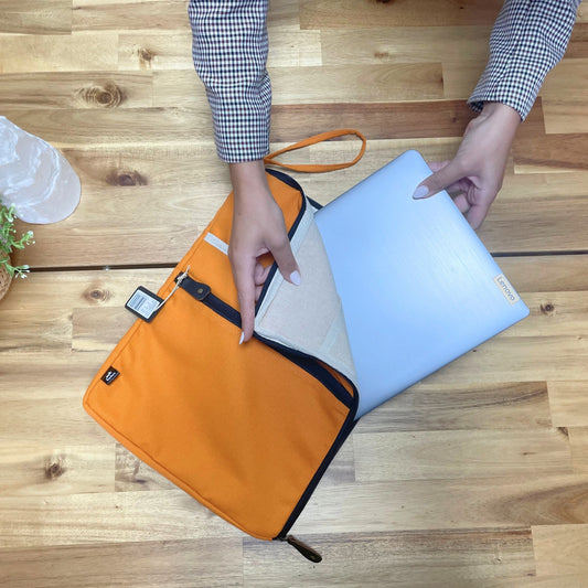 Large vibrant orange canvas laptop pouch with a slim, minimalist design for tablets and laptops.