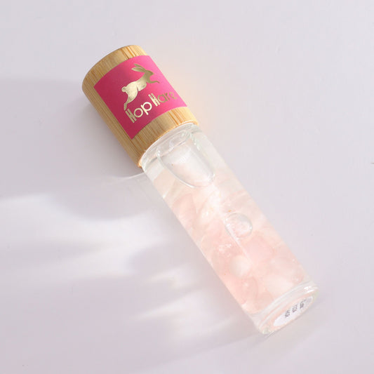 Gemstone essential oil roll-on bottle featuring a tarot-inspired label for The Lovers and infused with crystals.