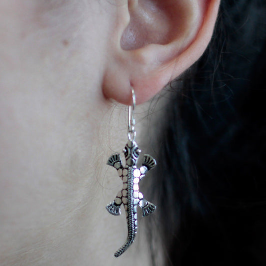 Detailed 925 sterling silver lizard drop earrings with a polished finish hanging on hooks.