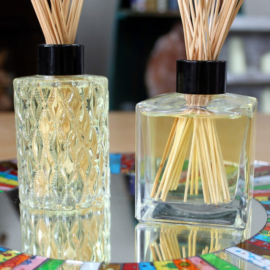 Clear round 150ml heavy glass reed diffuser bottle with a sleek black screw-on cap and plastic transit plug.