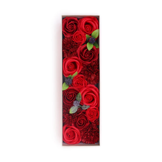 Elegant long gift box filled with realistic red soap rose petals and delicate greenery.