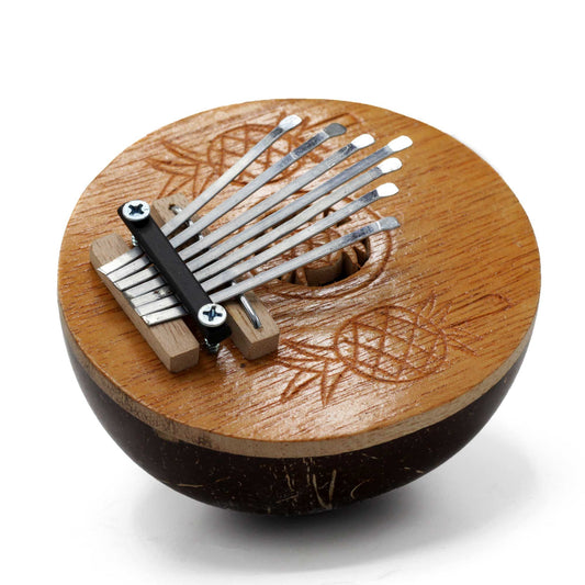 Handcrafted mini kalimba thumb piano made from a polished natural coconut shell with metal tines.