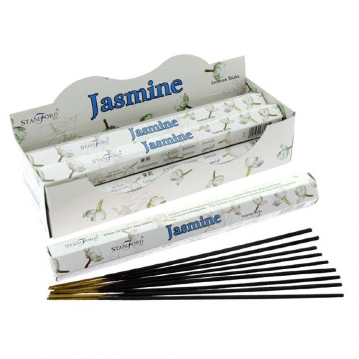 Hexagonal pack of floral jasmine incense sticks on a wooden surface with soft ambient lighting.