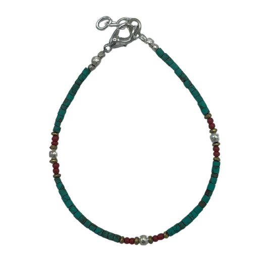 Handcrafted Nepalese bracelet featuring vibrant turquoise beads and earthy stone accents on a delicate cord.