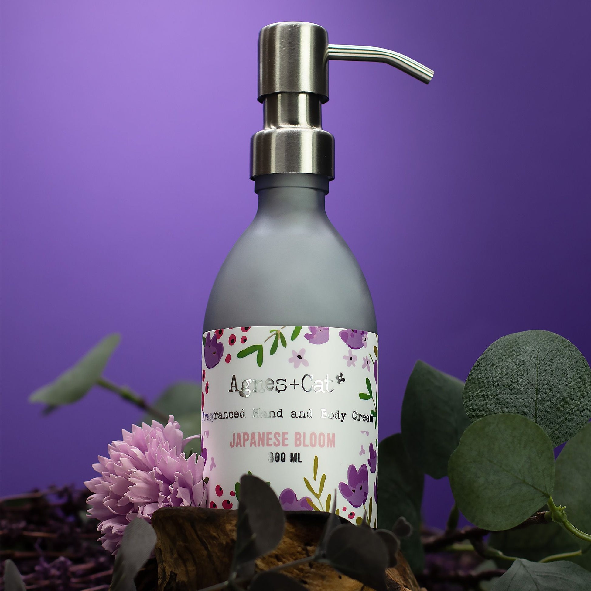 A jar of floral-scented white hand and body cream with a minimalist label on a neutral background.