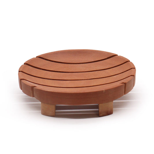 A smooth, circular dark mahogany wood soap dish with drainage ridges for natural soap bars.