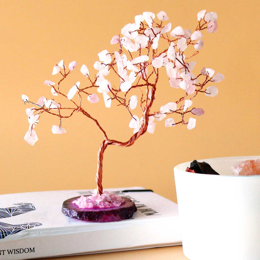 Large gemstone tree featuring delicate rose quartz leaves and a polished pink agate base with twisted wire branches.