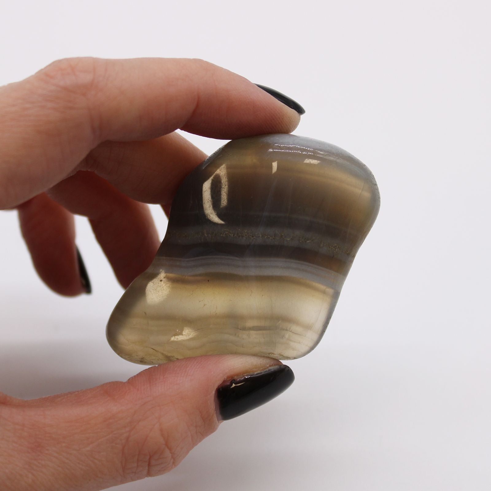 Large, smooth tumbled Botswana grey agate stones featuring natural banded patterns in shades of grey and white.