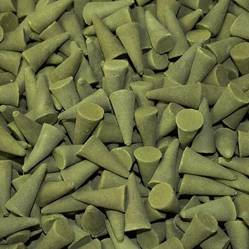 A large collection of aromatic green incense cones with a smooth, uniform texture and pointed tips.