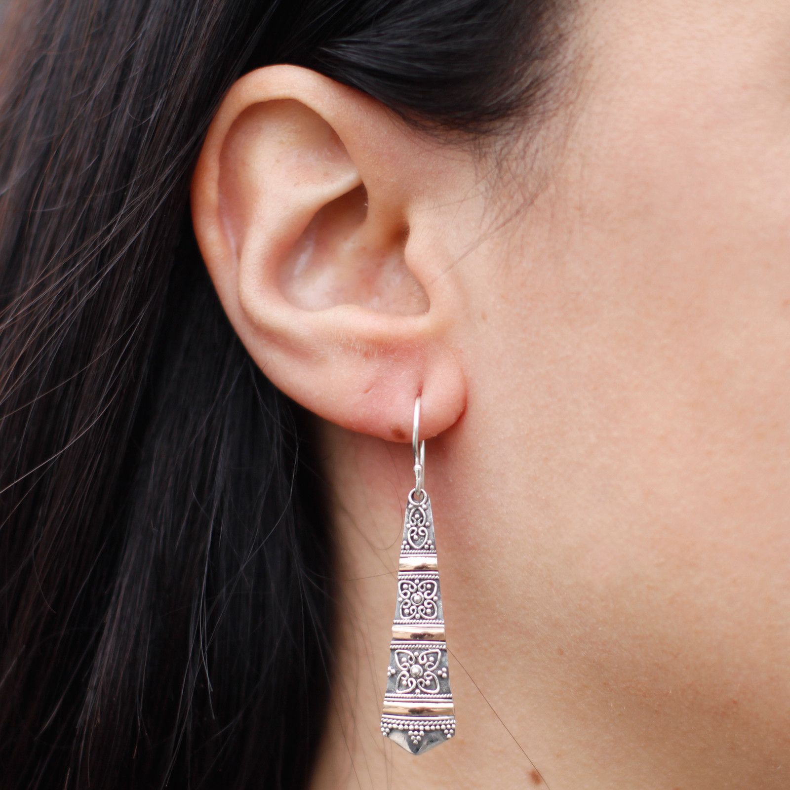 Elegant mixed metal drop earrings featuring a combination of silver and gold in an exotic tribal-inspired design.