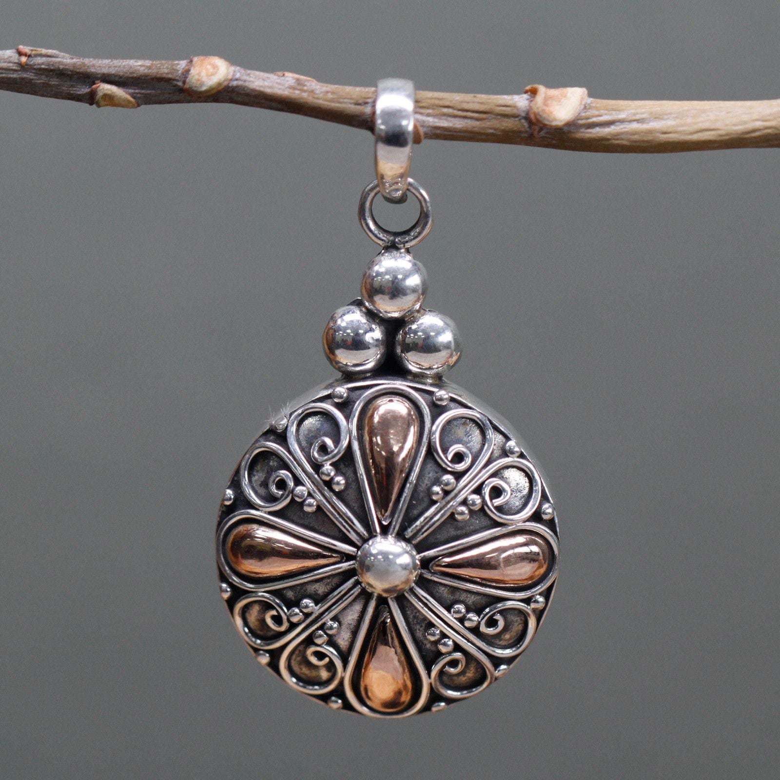 Elegant mixed metal pendant featuring a classic round design in polished silver and gold finishes.