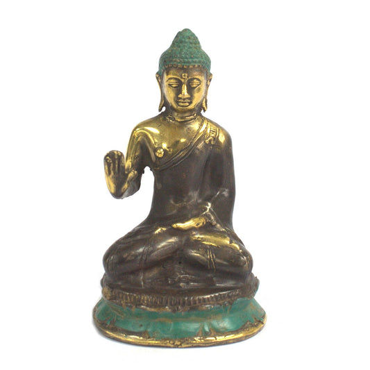 Small brass Buddha statue sitting in meditation with one hand raised, featuring intricate traditional details.