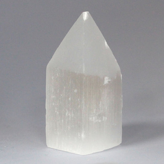 Tall white Selenite pencil point tower with a milky crystalline structure and translucent finish.