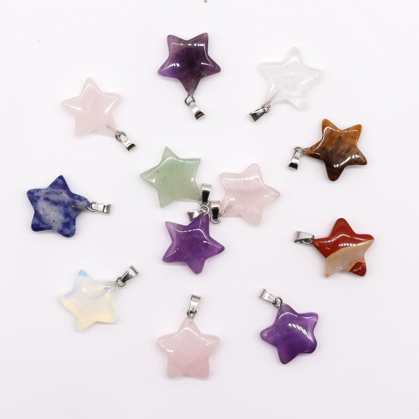 Twelve assorted star-shaped gemstone pendants in various colours and natural stone patterns.
