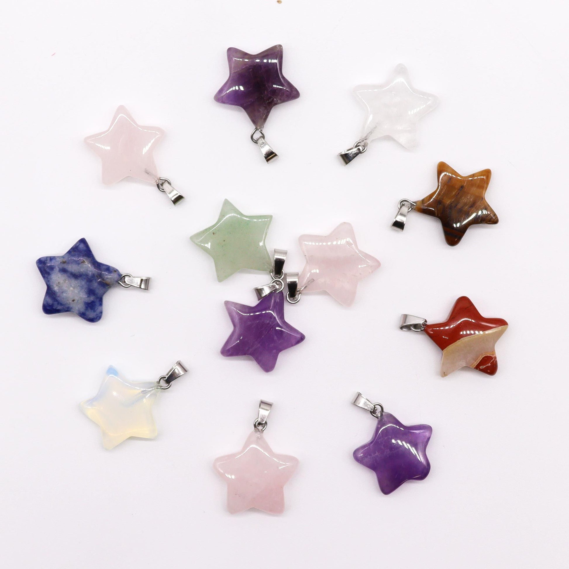 Twelve assorted star-shaped gemstone pendants in various colours and natural stone patterns.
