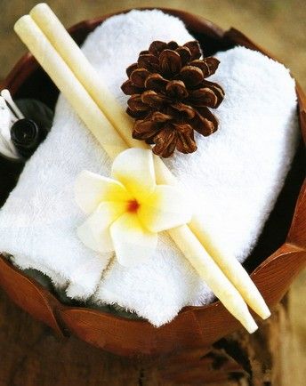 Two long, tapered orange scented ear candles placed side by side on a neutral background.