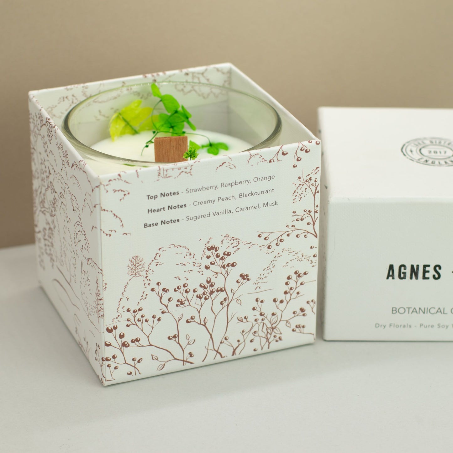 Hand-poured botanical soy wax candle topped with dried flowers in a glass jar.