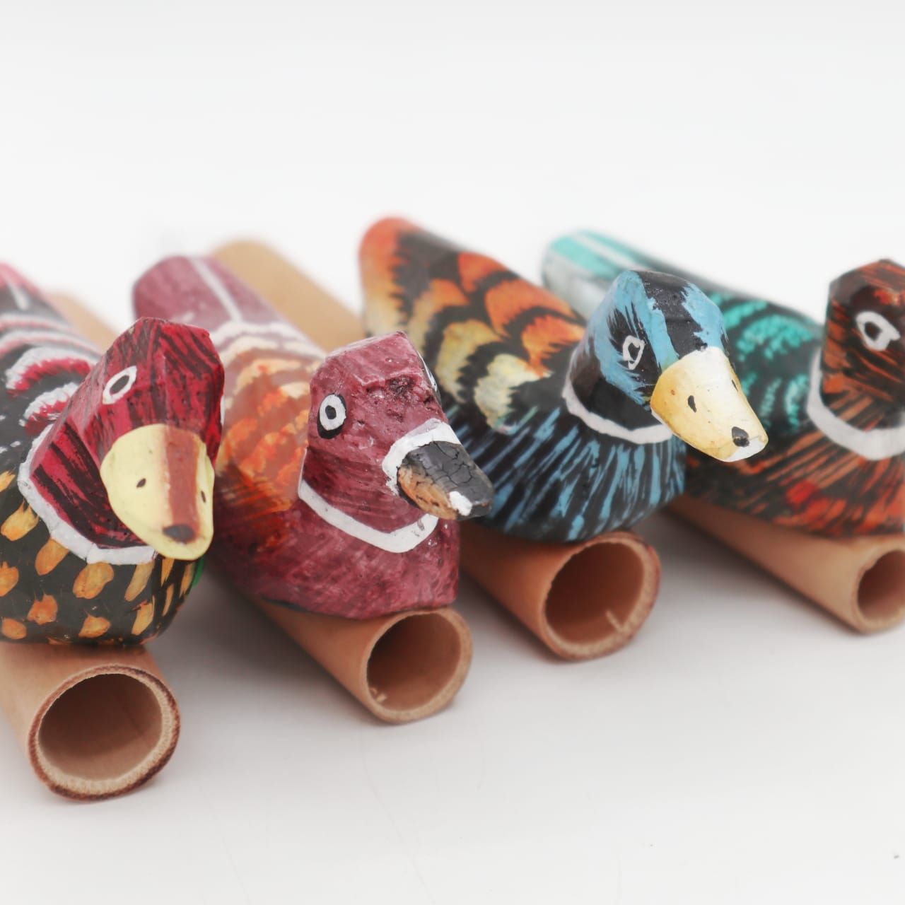 Small brightly coloured bird whistle shaped like a duck, available in various random colours.