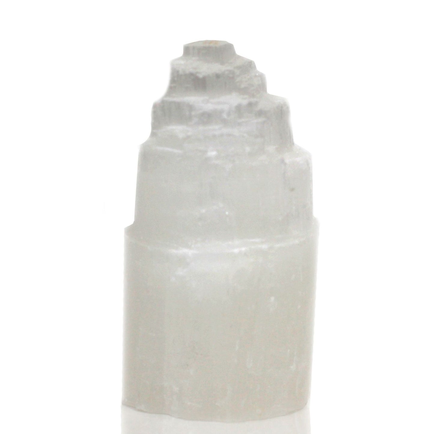Glowing white natural selenite crystal tower lamp with a textured skyscraper shape on a wooden base.