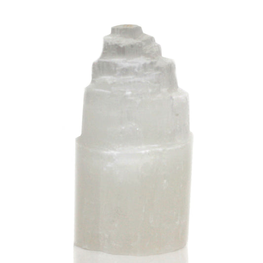 Glowing white natural selenite crystal tower lamp with a textured skyscraper shape on a wooden base.