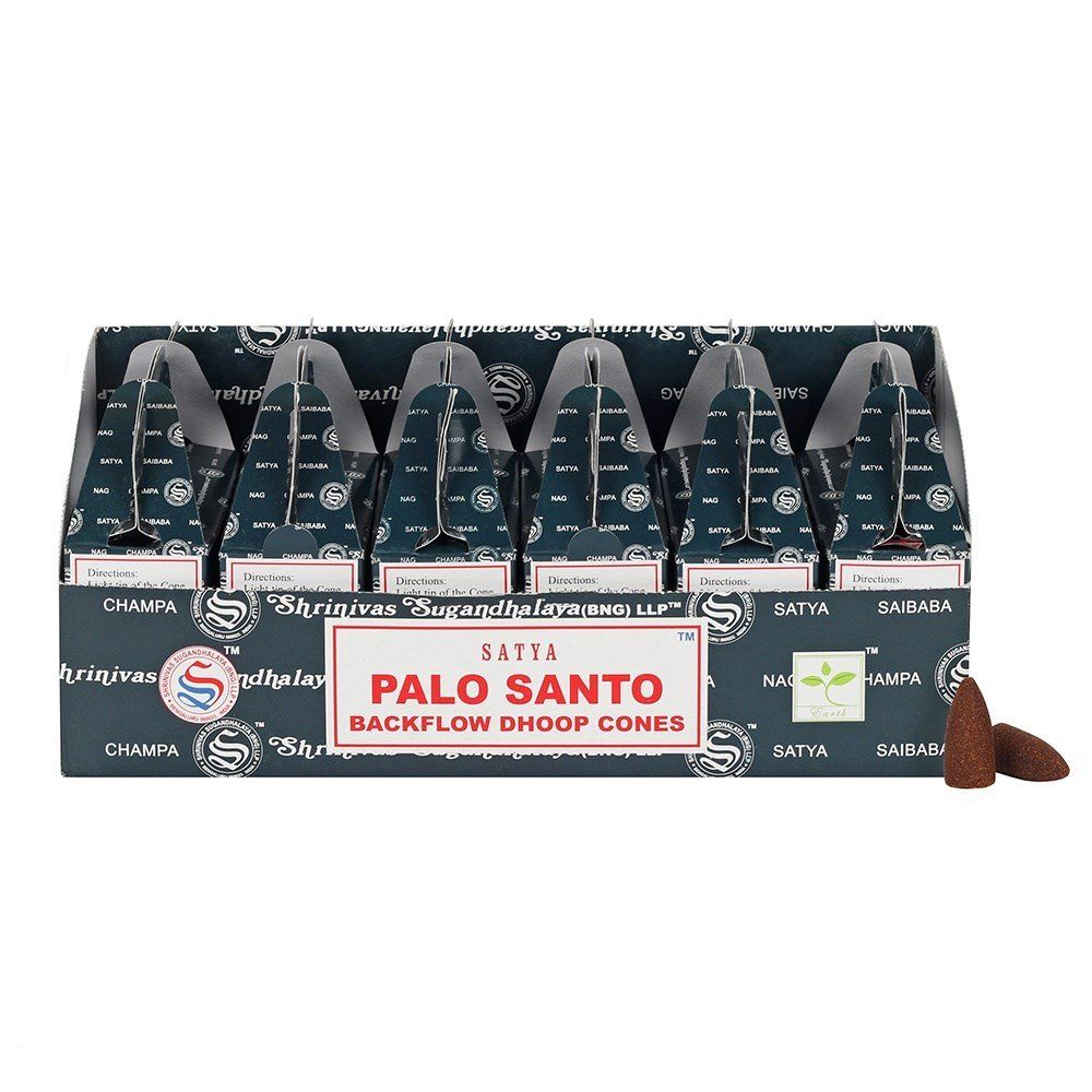 Box of Palo Santo backflow incense cones beside a stack of circular dhoop cones on a rustic surface.